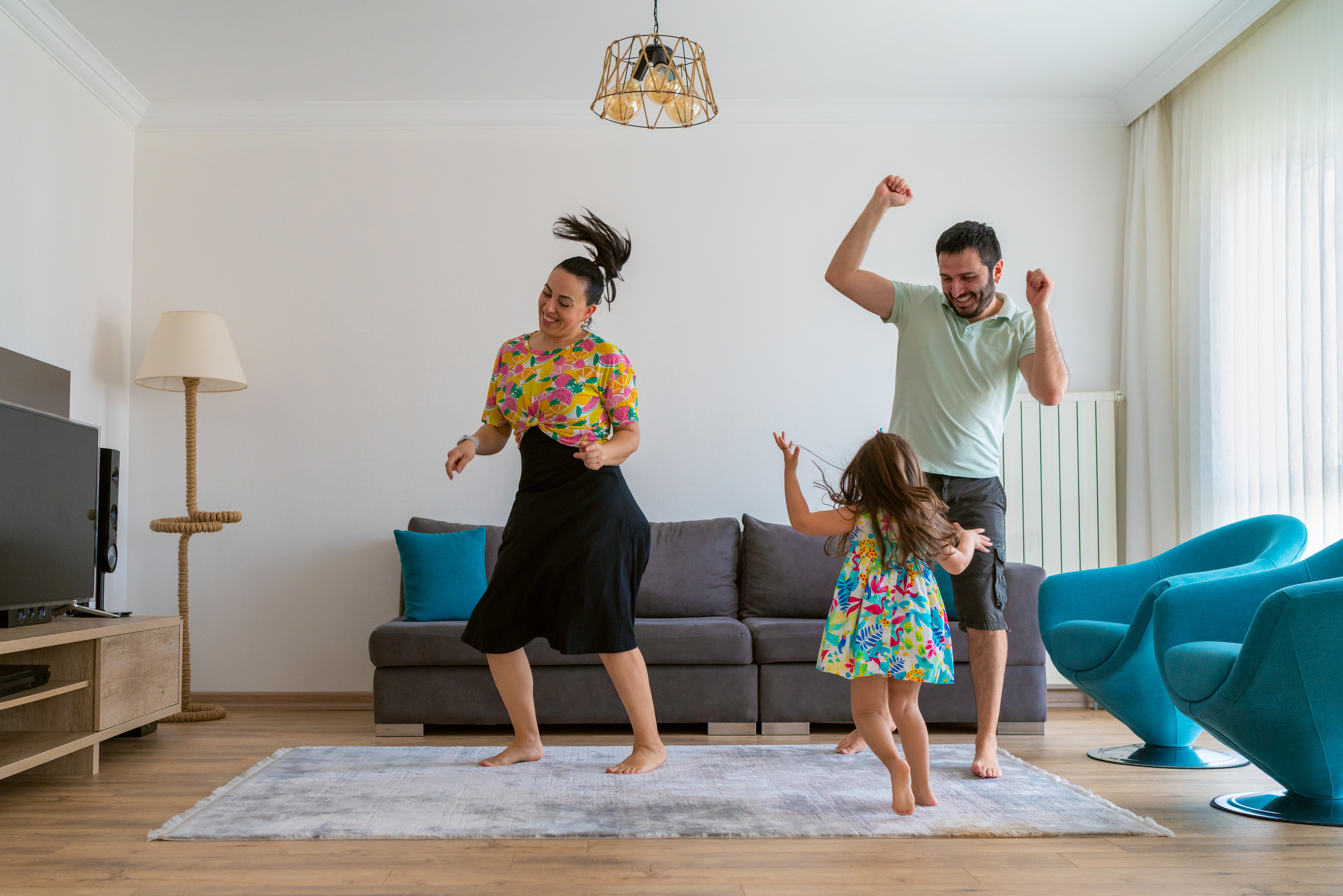 A joyful family dancing together in their cozy living room, filled with laughter and warmth.